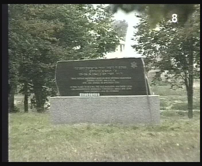 New Monument at the grave of Jewish men at the Ejszyszki Jewish Cemetery murder site. Screenshot from the film "There Once Was a Town," 1999, Yad Vashem, The Visual Center V 1725