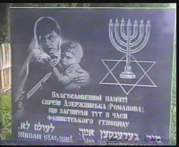 Monument (erected in 2001) at the Public Garden murder site. A screenshot from the film "Report about the Day of Sorrow and Memory for the Victims of the War in the Town of Romanov, Zhitomir Region" 2008, Yad Vashem, The Visual Center V 4243